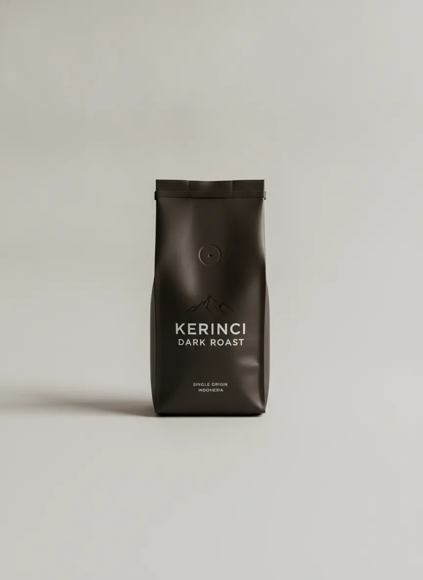 A dark-roast Kerinci coffee bag resting on a pale neutral gray surface under even studio light