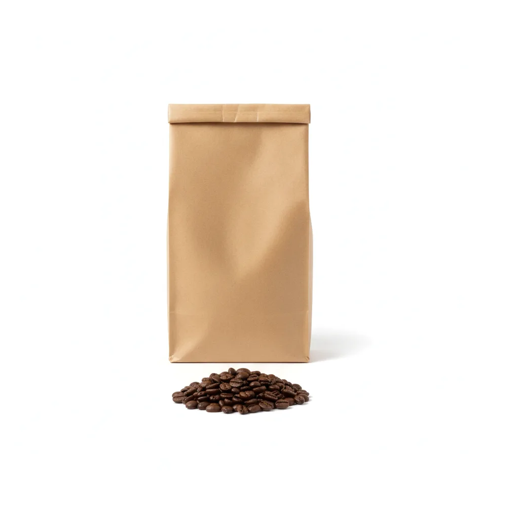 A kraft coffee bag beside a small pile of dark roast beans on white.