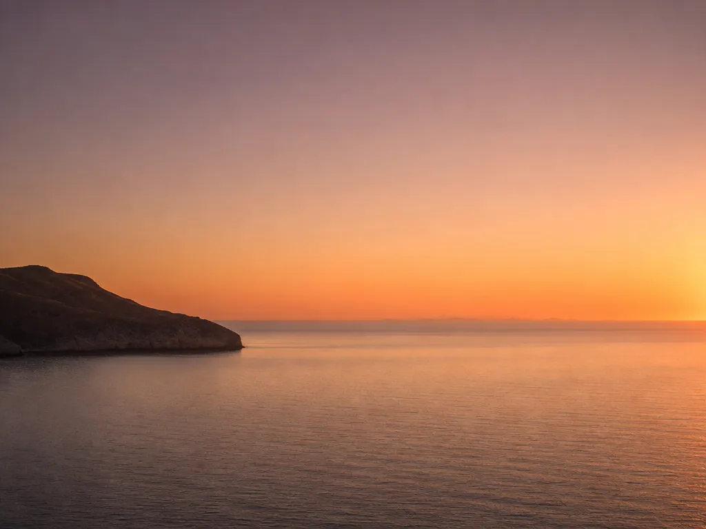 A coastal horizon at golden hour with smooth tonal gradients across sky and water