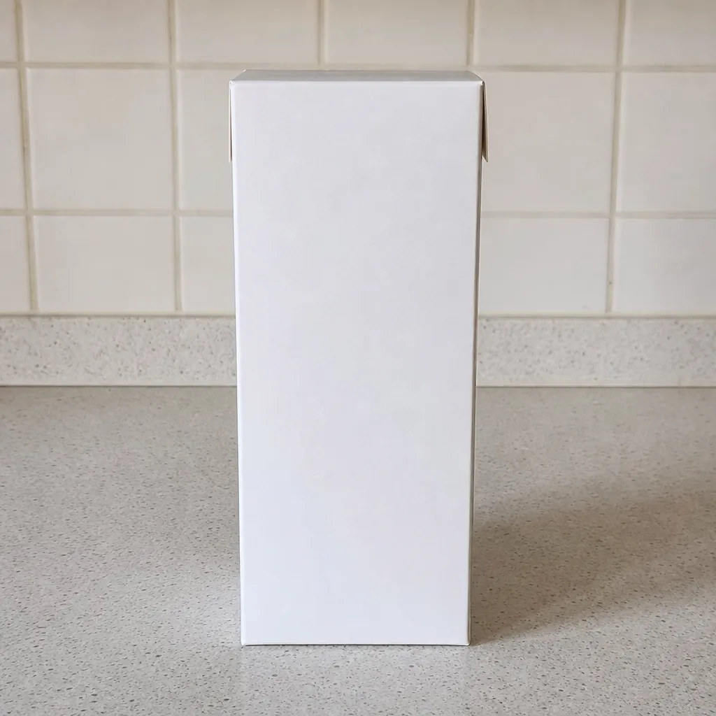 A blank unlabelled paper carton standing upright on a plain kitchen counter.