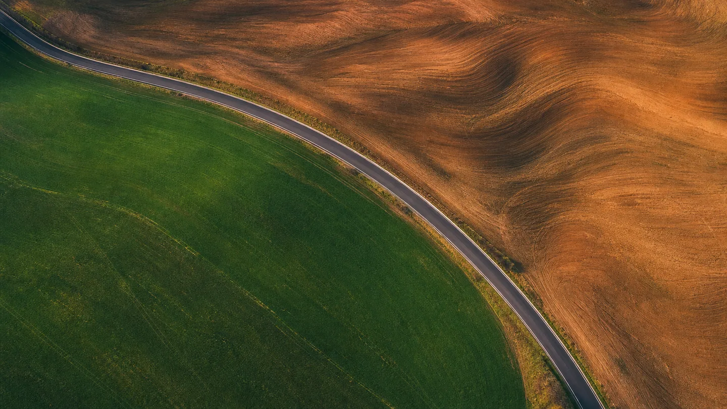 An overhead view of a curving road across open terrain