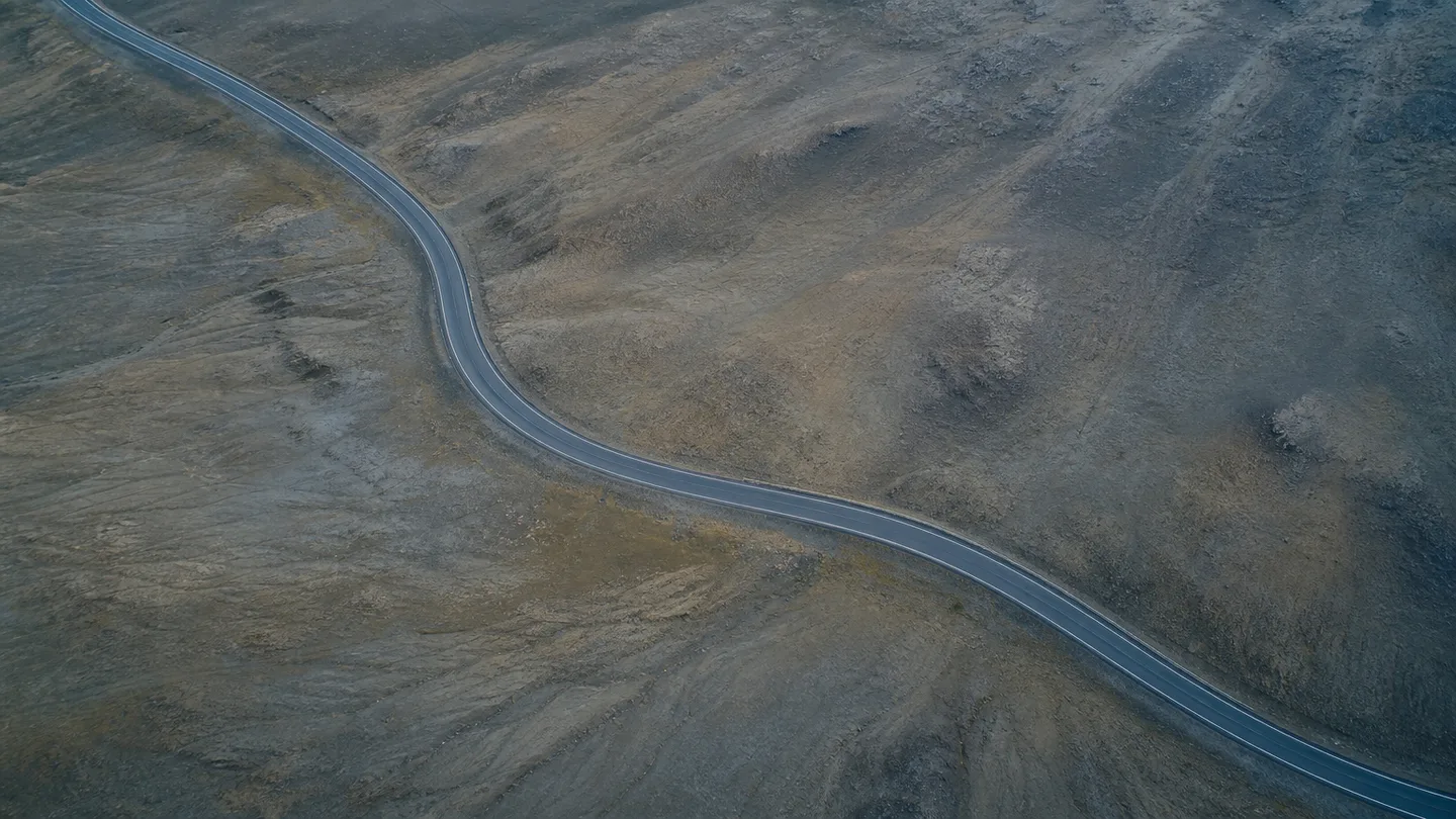 An aerial view of a curving road across open terrain.