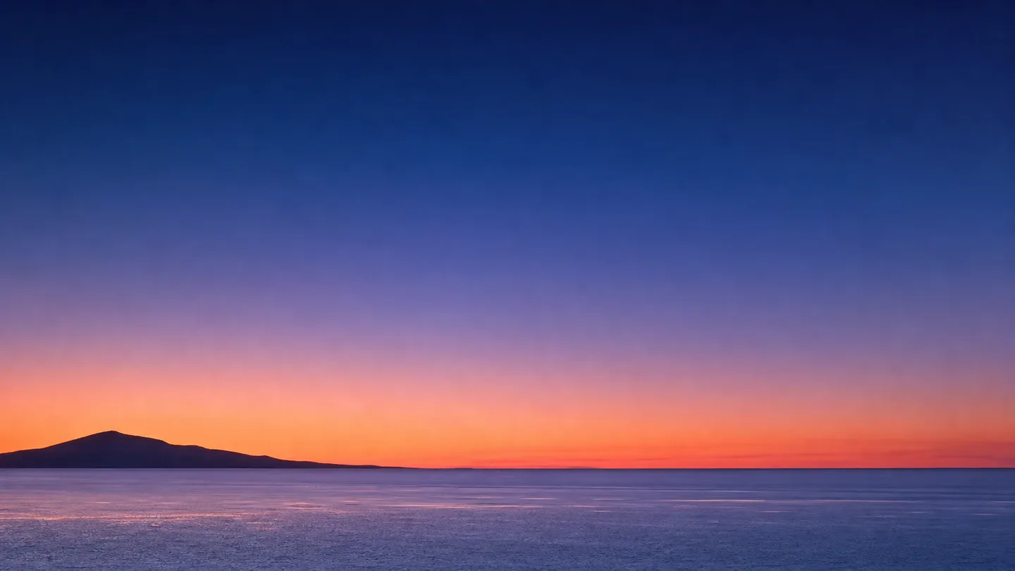 A calm gradient sky at dusk over a flat horizon.